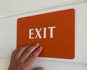 Braille exit sign