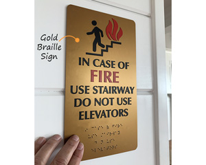 Braille fire exit sign, in gold