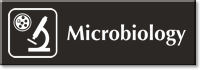 Microbiology Engraved Sign with Microscope and Bacteria's Symbol