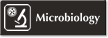 Microbiology Engraved Sign with Microscope and Bacteria's Symbol