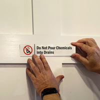 Do Not Pour Chemicals Into Drains Sign on a Door