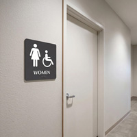 Braille women’s room sign with ADA symbol